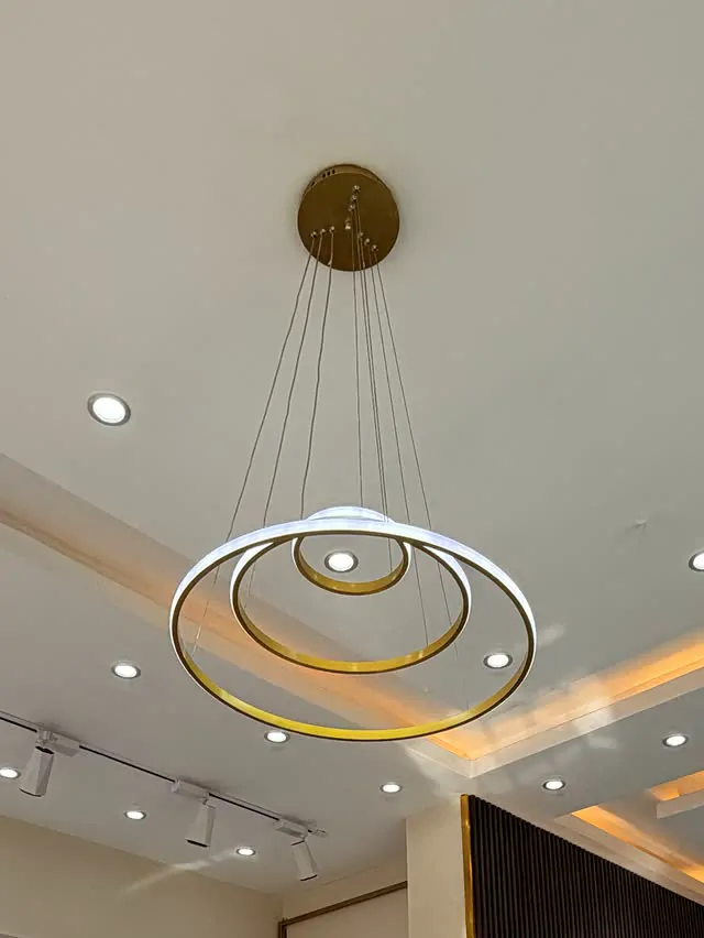 The gold ring chandelier glowing on the cream ceiling of Sultan Kids