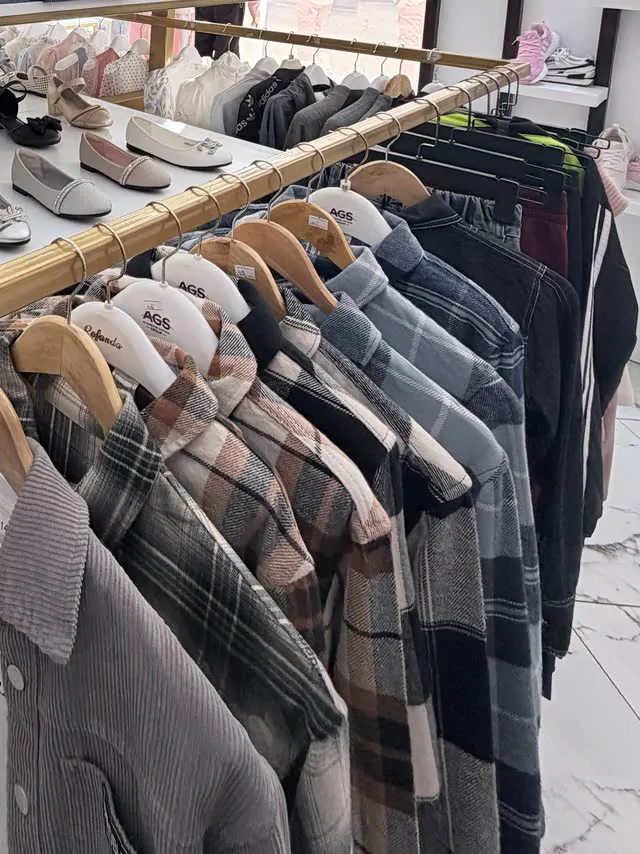 Checked shirts and jackets on a gold rail